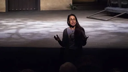 a woman on a theatre stage talking