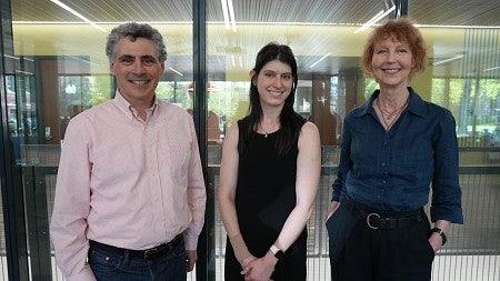 Three people standing in front of a window