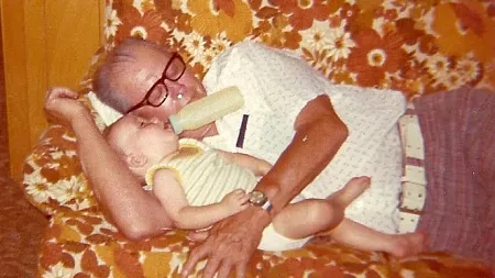 photo upload from the 1970s of a baby and his grandfather on a couch
