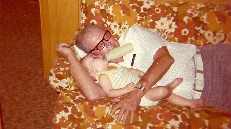 photo upload from the 1970s of a baby and his grandfather on a couch