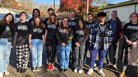Group of students posing together standing in a street