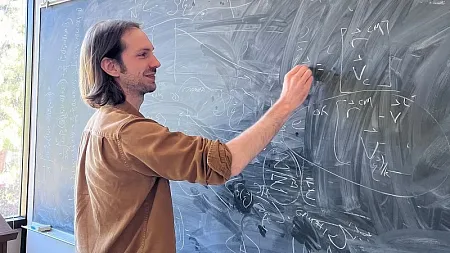 a person writes on a chalkboard