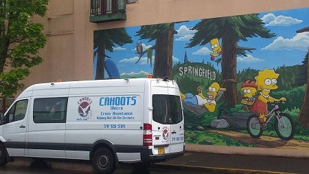 a white van in front of a simpsons mural