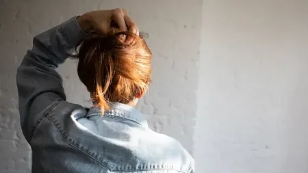 stock photo of a person's back of their head staring at a wall