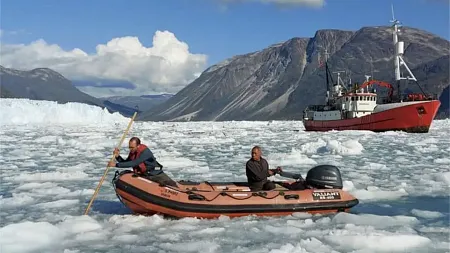 people on a raft boat in a glacier sea