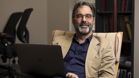a person sitting in a chair with a laptop