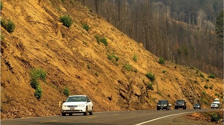 a car driving past a barren hillside