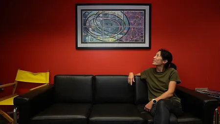 a person sits on a couch in front of a red wall
