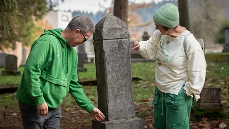 two people sitting beside a tombstone on university campus