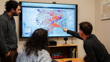 two people at a computer looking at a map