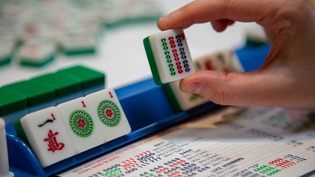 person looking at mahjong tiles while playing the game