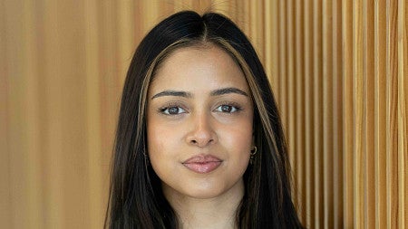 a headshot of a person with a brown wooded background