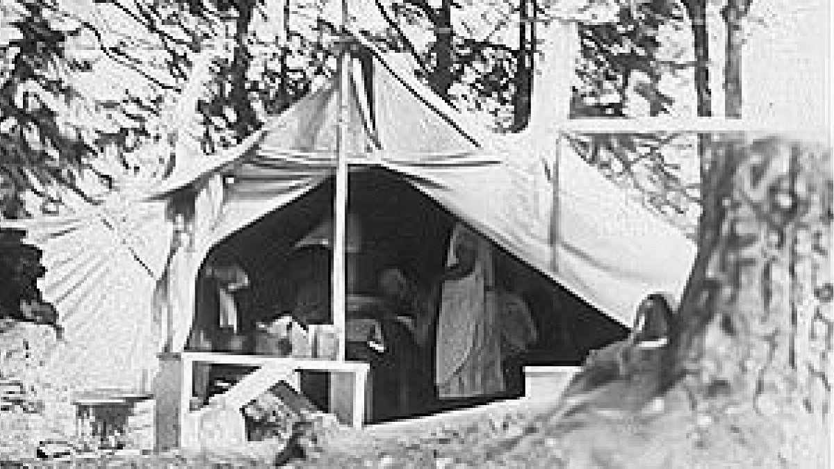 Old photo of early OIMB site with a tent and equipment in view