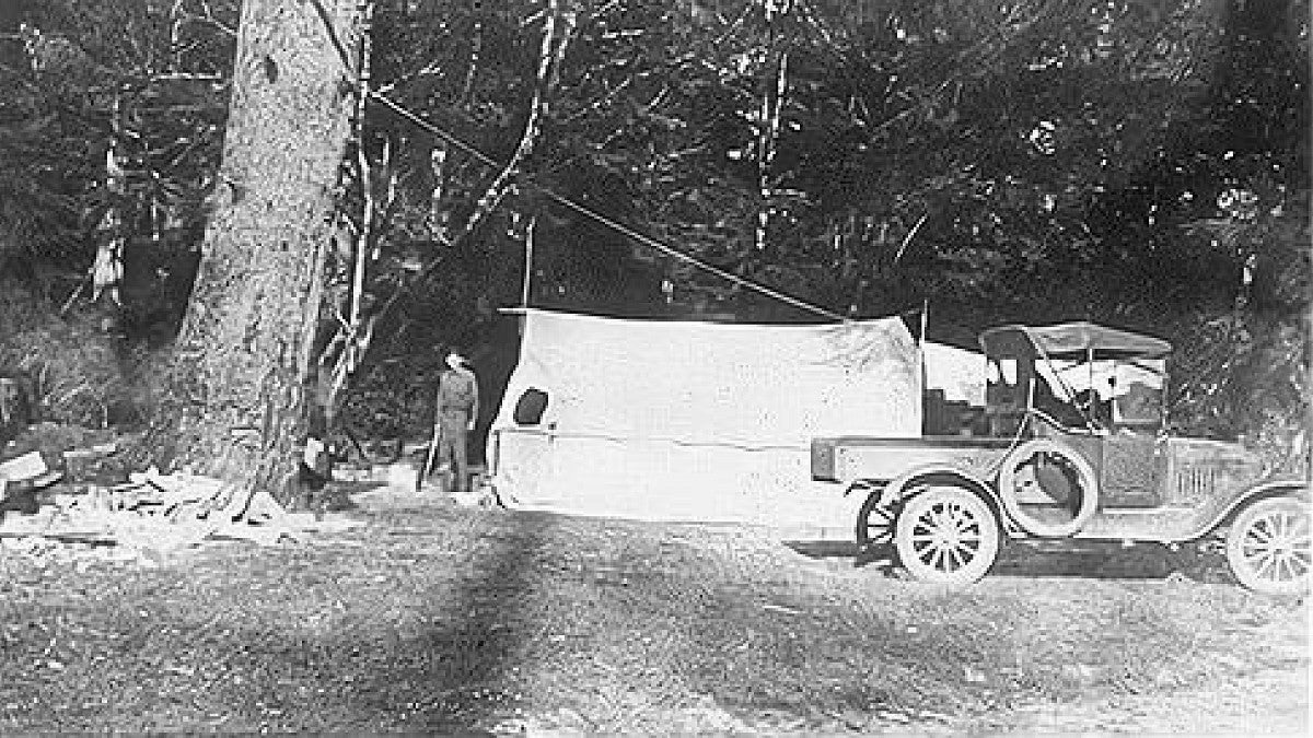 Old photo of early OIMB site with a tent and truck in view