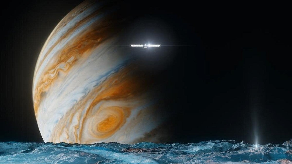 A space probe floating above a frozen moon with Jupiter in the background
