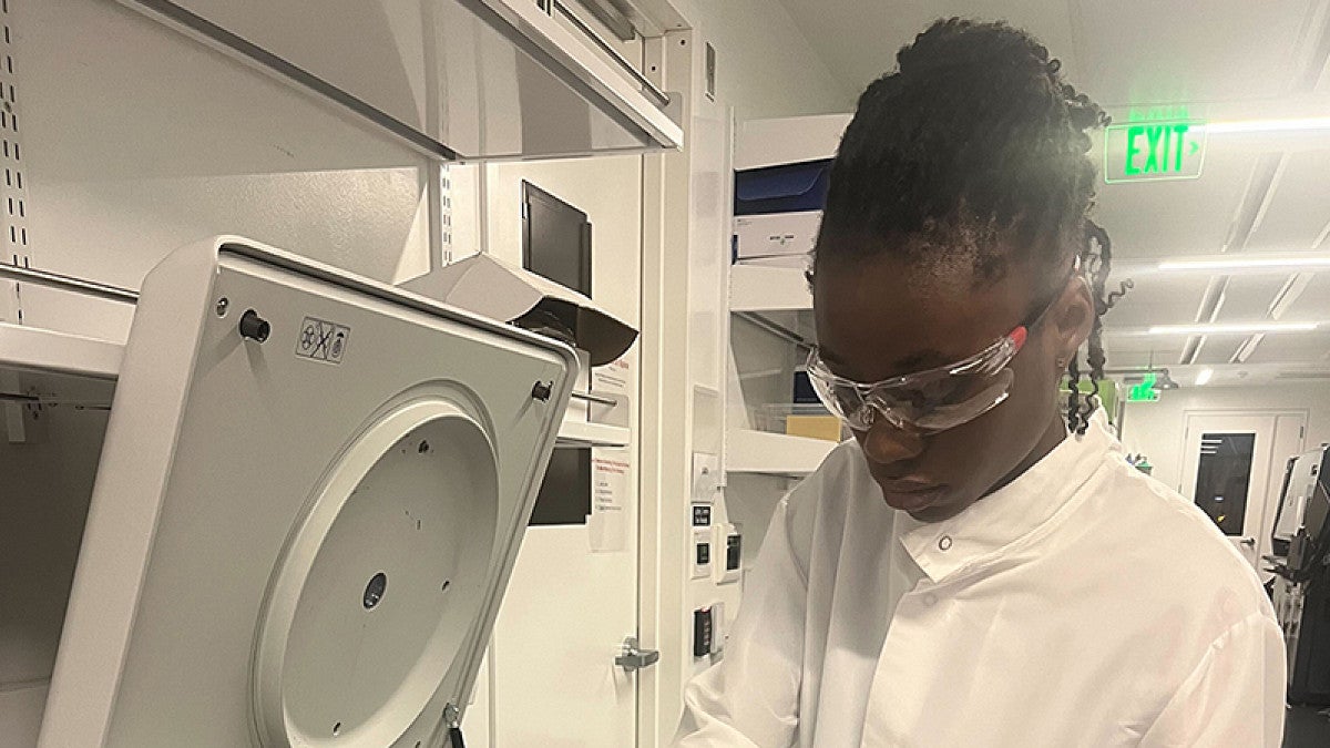Student researcher working in a lab with equipment