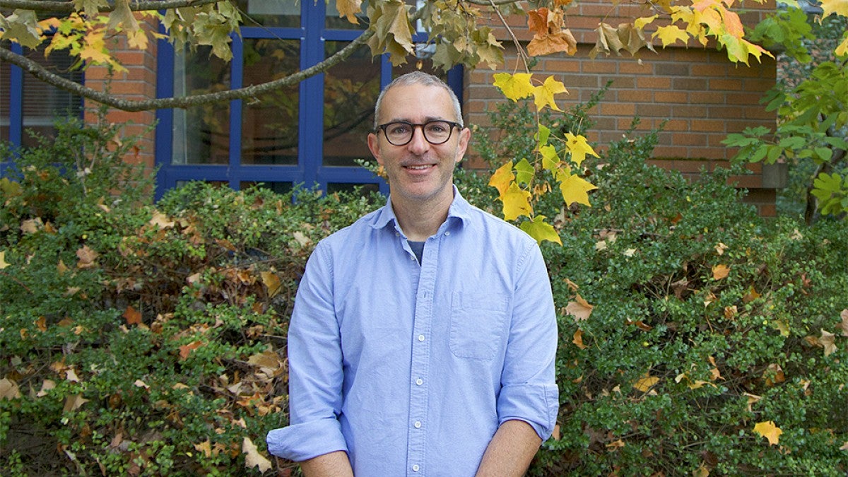 Brice Kuhl standing in front of an ivy covered building