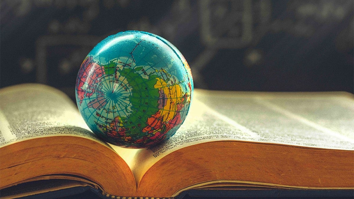 A miniature globe resting on top of an open book