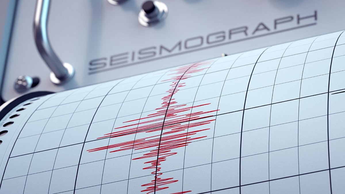 A seismograph needle marking in red ink