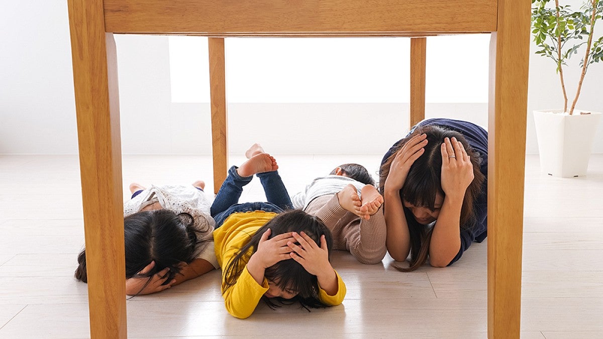 Kids ducking under table for earthquake drill