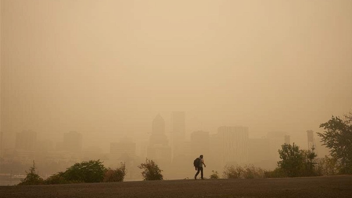 Person walking along a ridge in surrounded by smoke