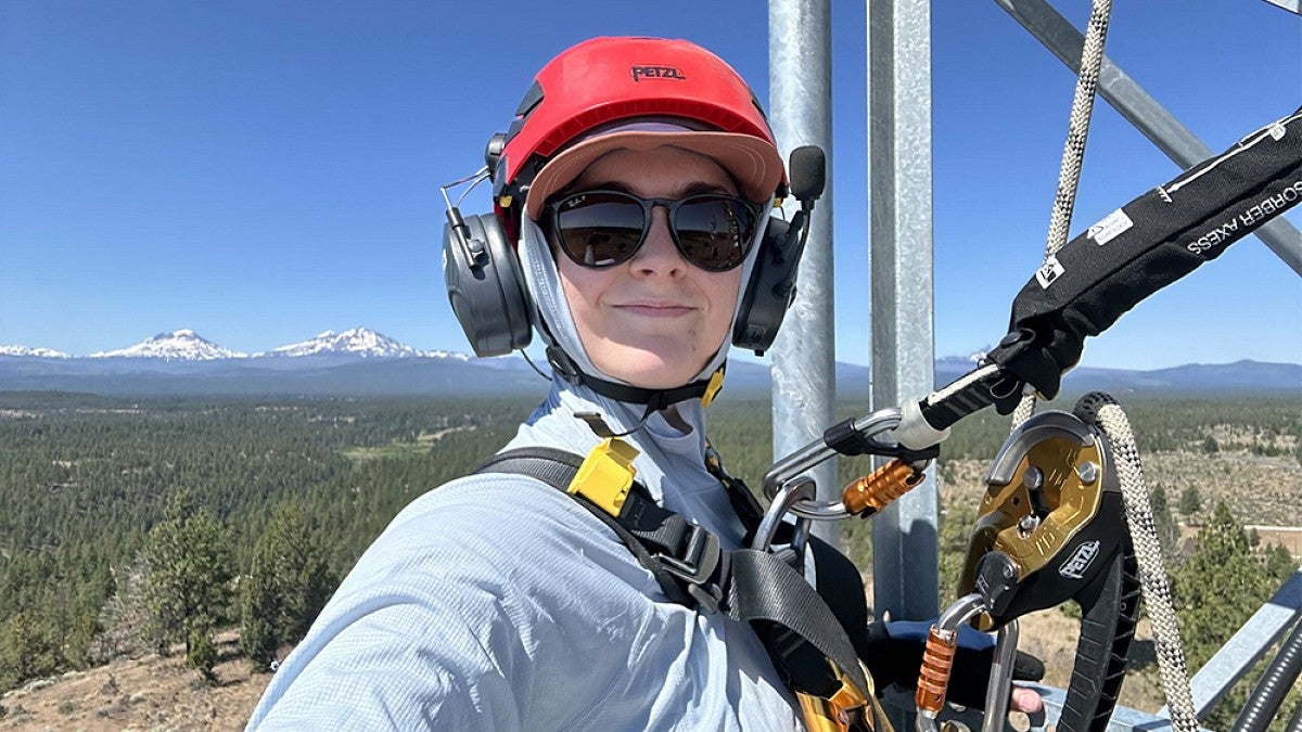 A person atop of a tower installing equipment