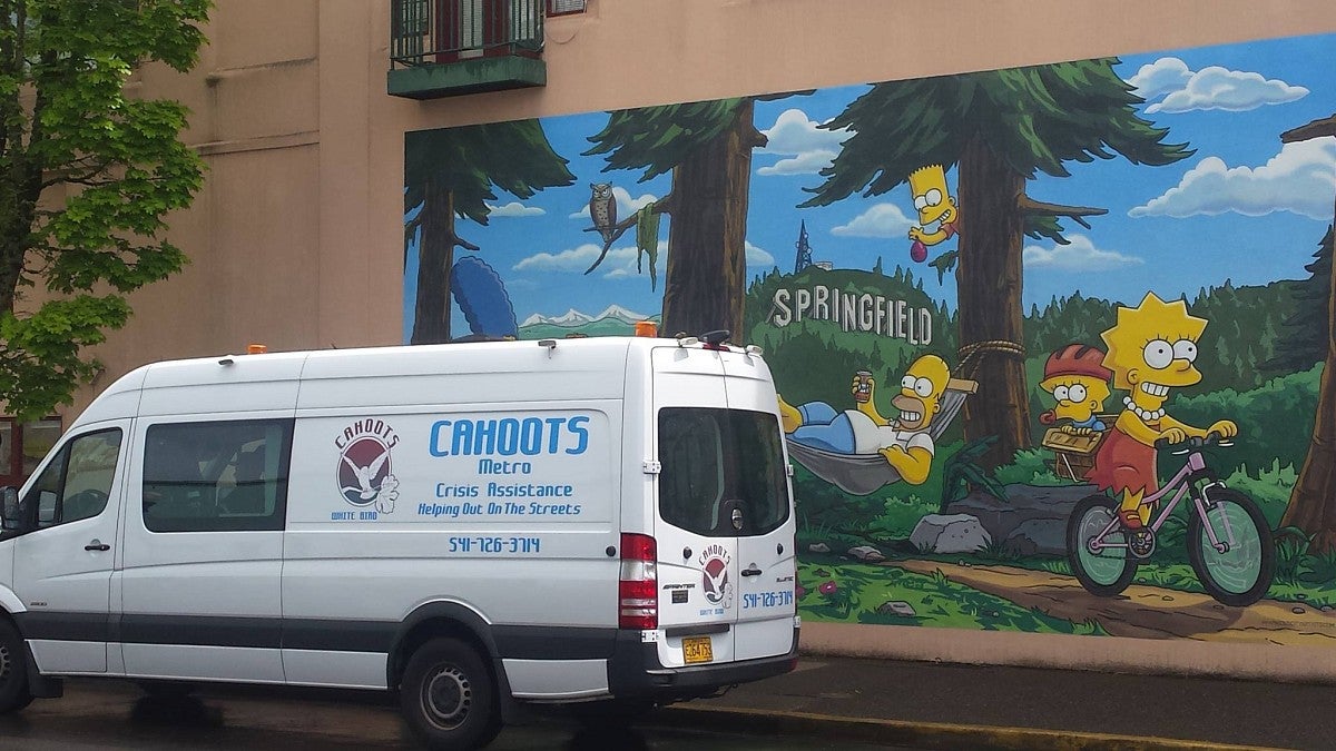 a white van in front of a simpsons mural