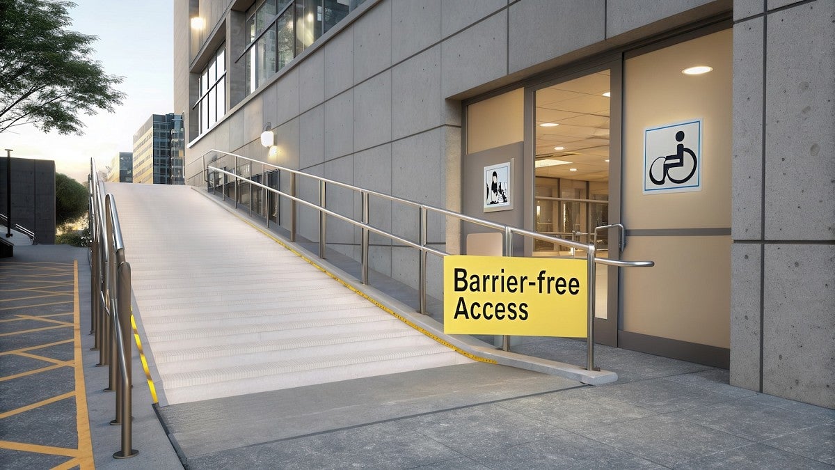 accessibility ramp going up with doors and wheelchair access signs on the doors