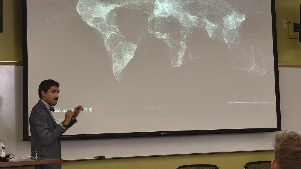a person leading a classroom lecture with a map behind him
