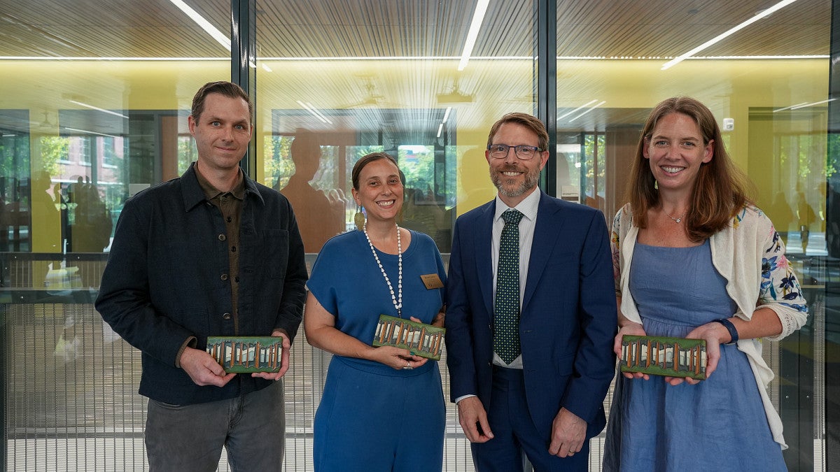 three faculty award winners pose with dean of college of arts and sciences