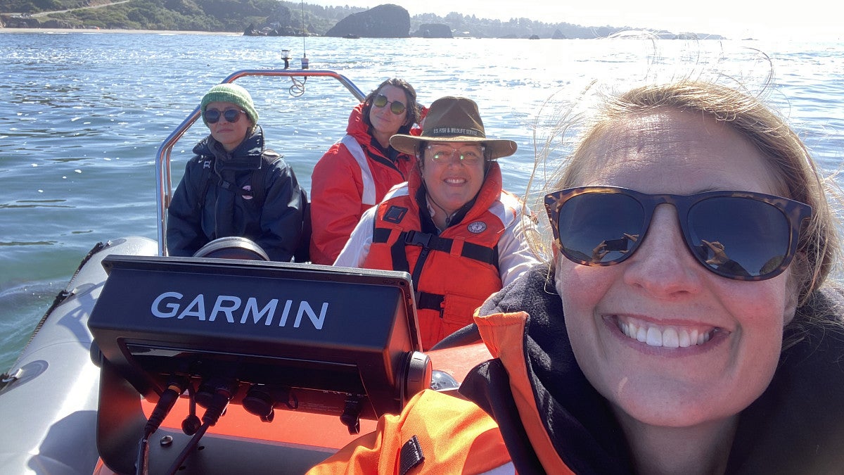 annie pollard and friends on a boat in the ocean wearing life jackets