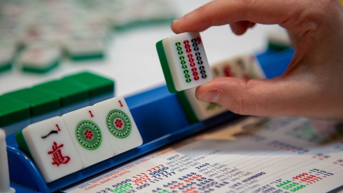 person looking at mahjong tiles while playing the game