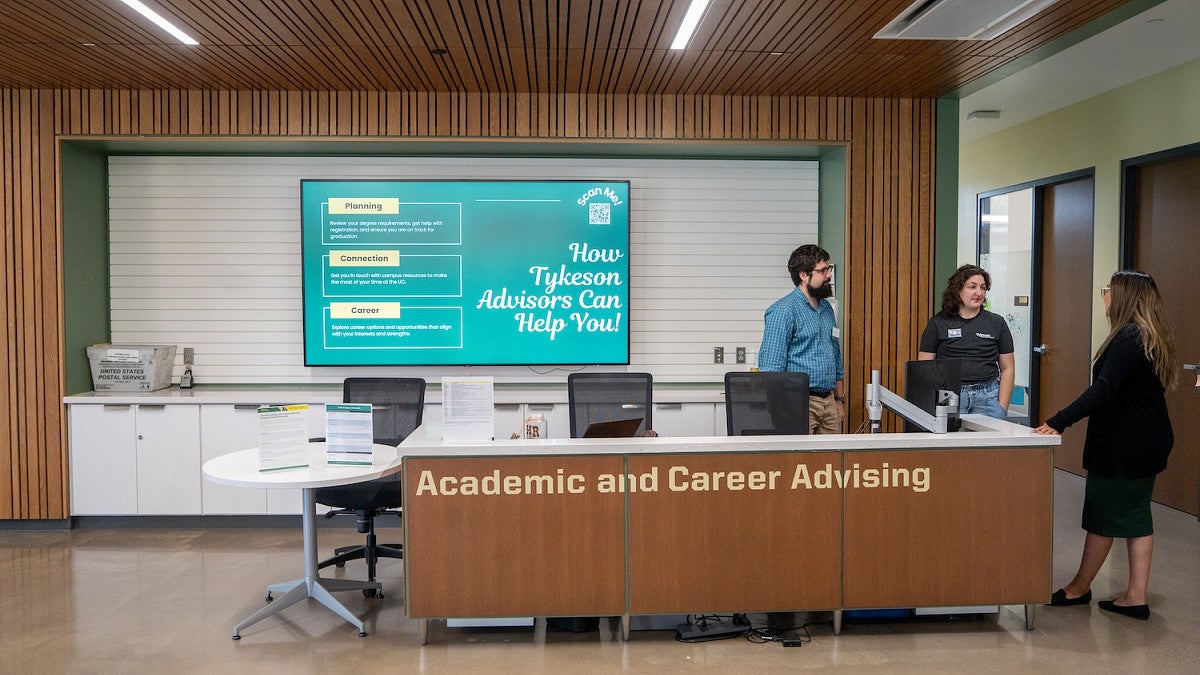 advisors chatting at the CAS Academic Advising desk on the first floor of Tykeson Hall