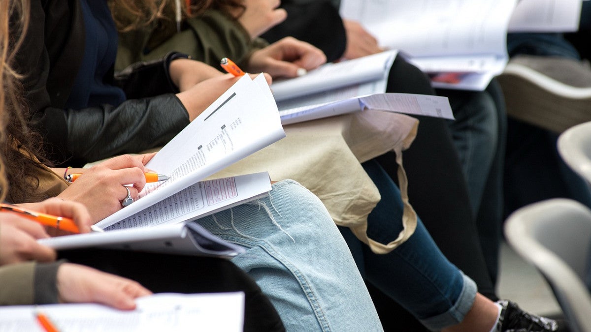 a group of students reading a paper