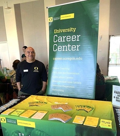 Brian Hubbell standing next UO Career Center banner