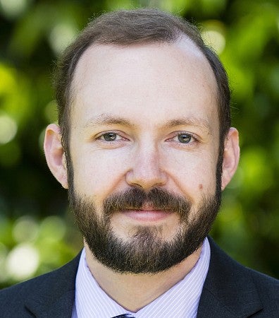 Man in front of a leafy background