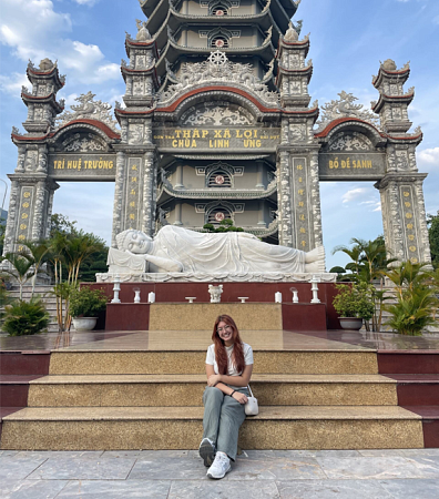 Dante James posing next to statue in Vietnam