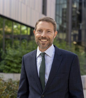 dean chris poulsen posing in front of Tykeson hall