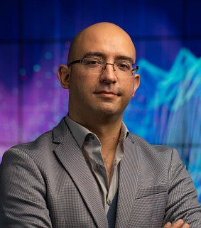 portrait of philosophy faculty ramon alvarado in front of colorful screen