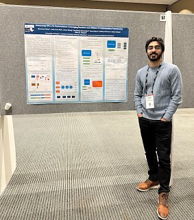 computer science doctoral alum hammad ather standing in front of his research poster at a graduate research symposium