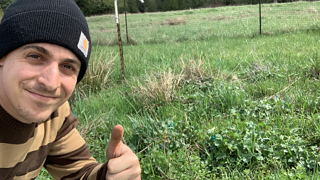 Alejandro Brambila poses with a thumbs up in a field