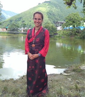 Student smiling with small lake and trees in background